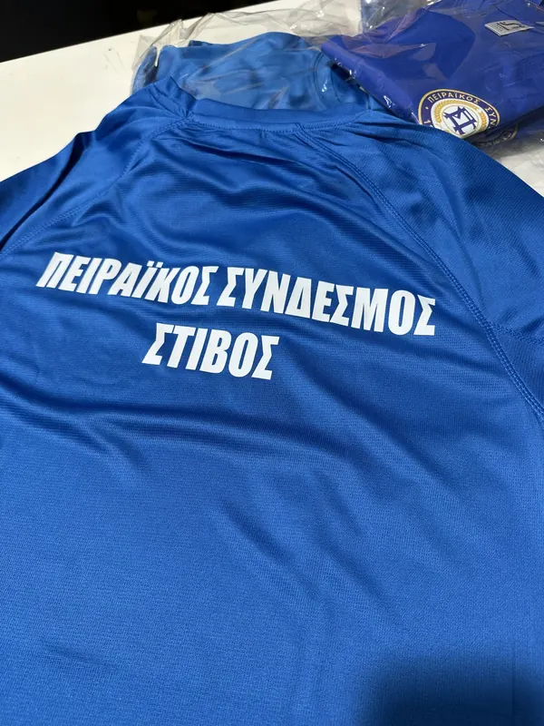 Μπλε μπλουζάκια με εκτύπωση για τον Πειραϊκό Σύνδεσμο Στίβου